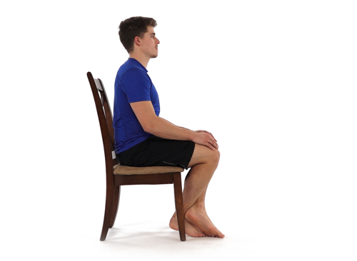 A man sat on a chair with his knees bent